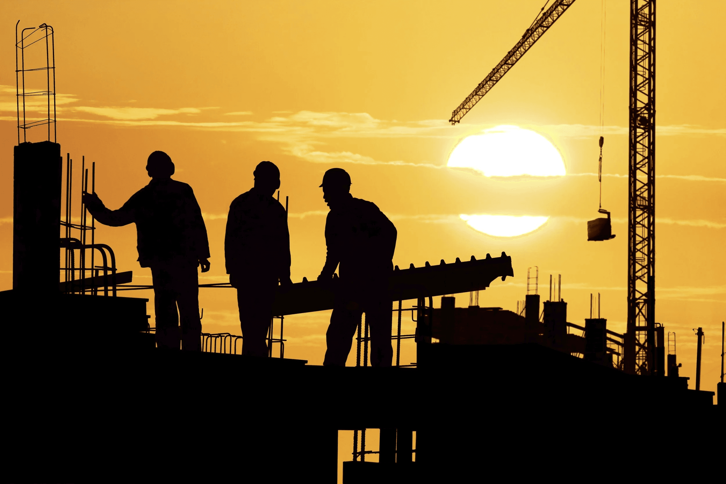 Workers at sunset on construction site